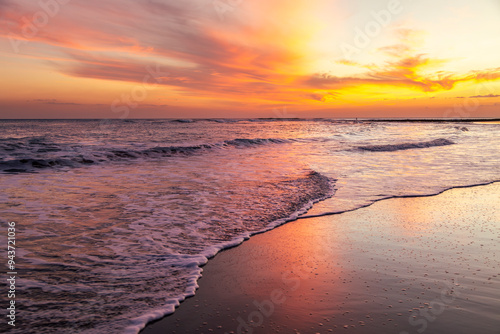 Fototapeta Naklejka Na Ścianę i Meble -  Serene sunset at Playa El Tunco, El Salvador, with gentle waves reflecting vibrant orange and pink hues. A tranquil seascape capturing the peaceful beauty of this popular coastal beach destination.