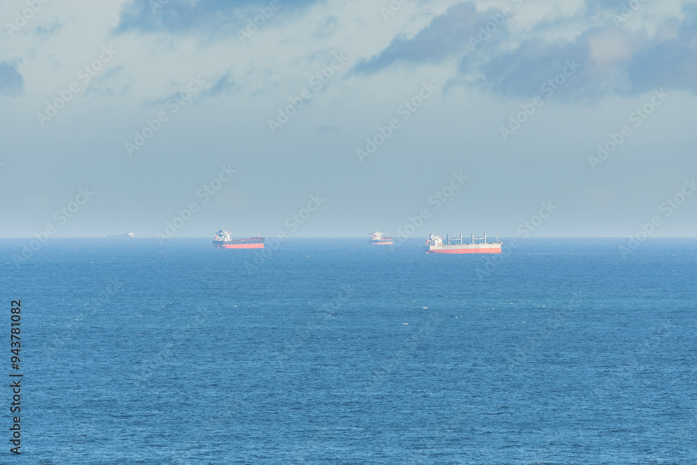 Cargo ships seen far away from the coast in the middle of the sea. Cargo ships seen far away from the coast in the middle of the sea.