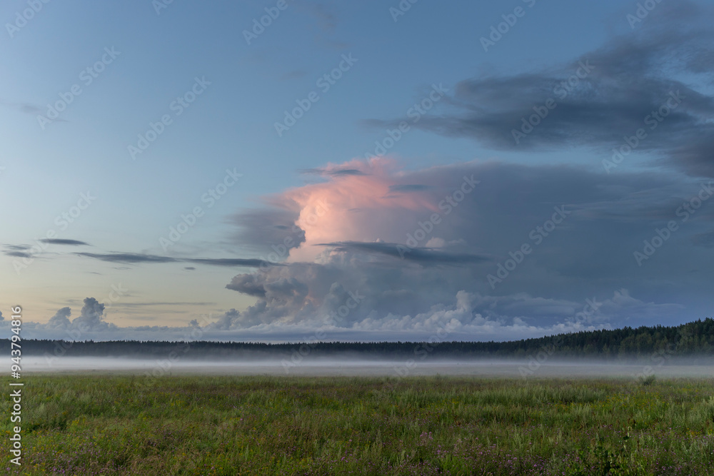 A large cloud in the sky with a pinkish hue A large cloud in the sky with a pinkish hue