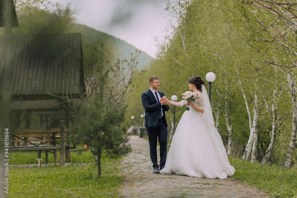 A bride and groom are walking down a path in a forest. The bride is holding a bouquet of flowers and the groom is holding a lantern. Scene is romantic and peaceful A bride and groom are walking down a path in a forest. The bride is holding a bouquet of flowers and the groom is holding a lantern. Scene is romantic and peaceful