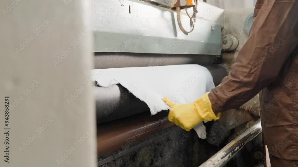 Animal Hides Being Processed On A Coating Machine In A Leather Factory. Industrial Machinery, Closeup Shot. Animal Hides Being Processed On A Coating Machine In A Leather Factory. Industrial Machinery, Closeup Shot.