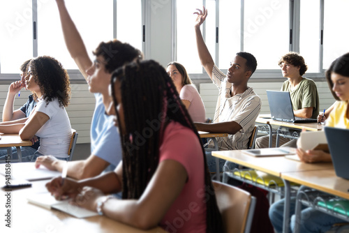 Billede på lærred Teen males raising hand to ask question about lesson in classroom