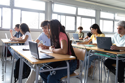 Group of multiracial teen high school student writing, doing homework, learning in class.