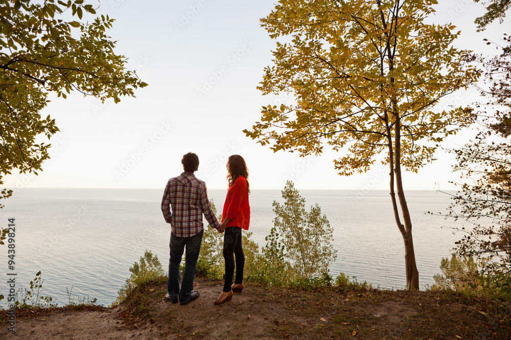Backview of Young Couple Standing at Edge of Cliff Looking out at View, Ontario, Canada Backview of Young Couple Standing at Edge of Cliff Looking out at View, Ontario, Canada