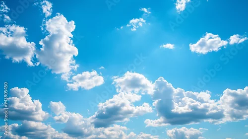 Obraz Cudowne niebo wypełniają białe cumulusowe chmury, które unoszą się leniwie na tle spokojnego, błękitnego nieba. 