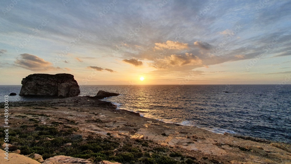 Obraz premium Stunning Sunset over Dwejra Bay, Gozo, Malta: Serene Coastal Landscape with Azure Waters and Golden Horizon