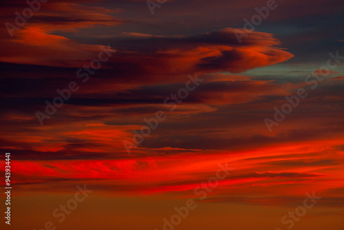 Brilliant red cloud formations create a dramatic, colorful sky; Calgary, Alberta, Canada