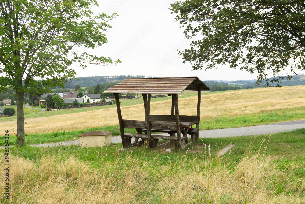 A rest area for hikers - wooden benches under a roof for resting and having a snack A rest area for hikers - wooden benches under a roof for resting and having a snack