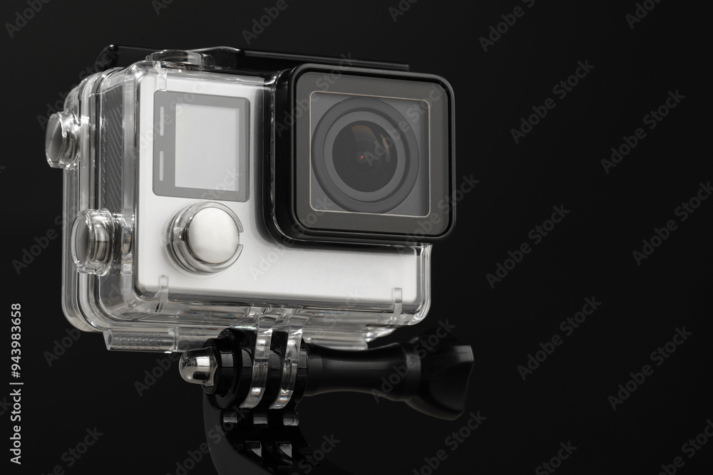 Modern action camera and mount against black background, closeup Modern action camera and mount against black background, closeup