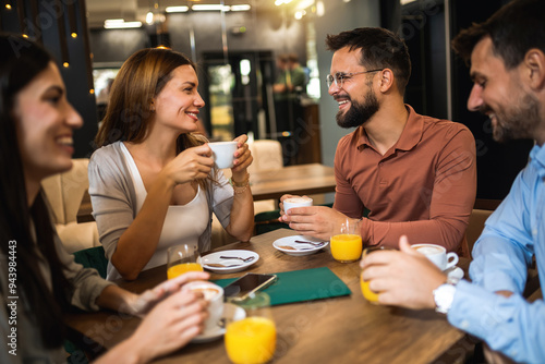 Group of friends met at the cafe. Drinking coffee and orange juice. Girl and guy are talking while the other friends are listening to them.