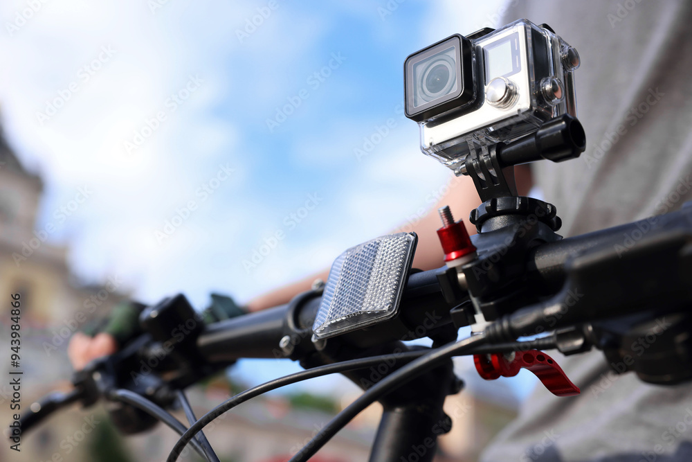 Man riding bicycle with modern action camera outdoors, closeup Man riding bicycle with modern action camera outdoors, closeup