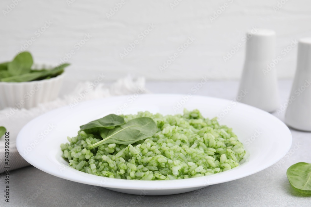 Delicious spinach risotto on light grey table, closeup Delicious spinach risotto on light grey table, closeup