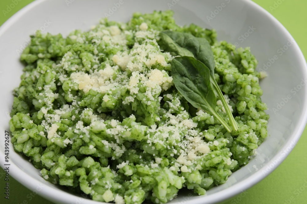 Delicious spinach risotto with parmesan cheese on light green background, closeup Delicious spinach risotto with parmesan cheese on light green background, closeup