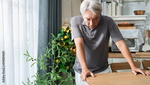 Konstfotografi Elderly Asian man suffering from accumulated stress, headache, unable to stand, using hands to support himself on the table, The concept of stress in old age and diseases that harm health