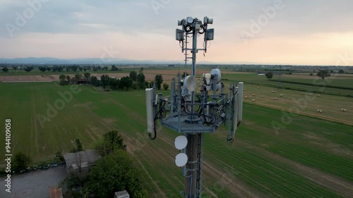 Wallpaper Mural Telecommunication tower stands prominently in a field surrounded by hay bales, showcasing a rural landscape under a dynamic sky Torontodigital.ca