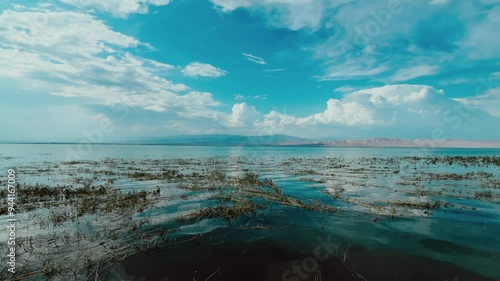 Kayrakkum reservoir. The Tajik Sea formed by the Kayrakkum hydroelectric dam on the Syrdarya River, on the territory of the Ferghana Valley. The reflection of the mountains in the blue water.4K photo