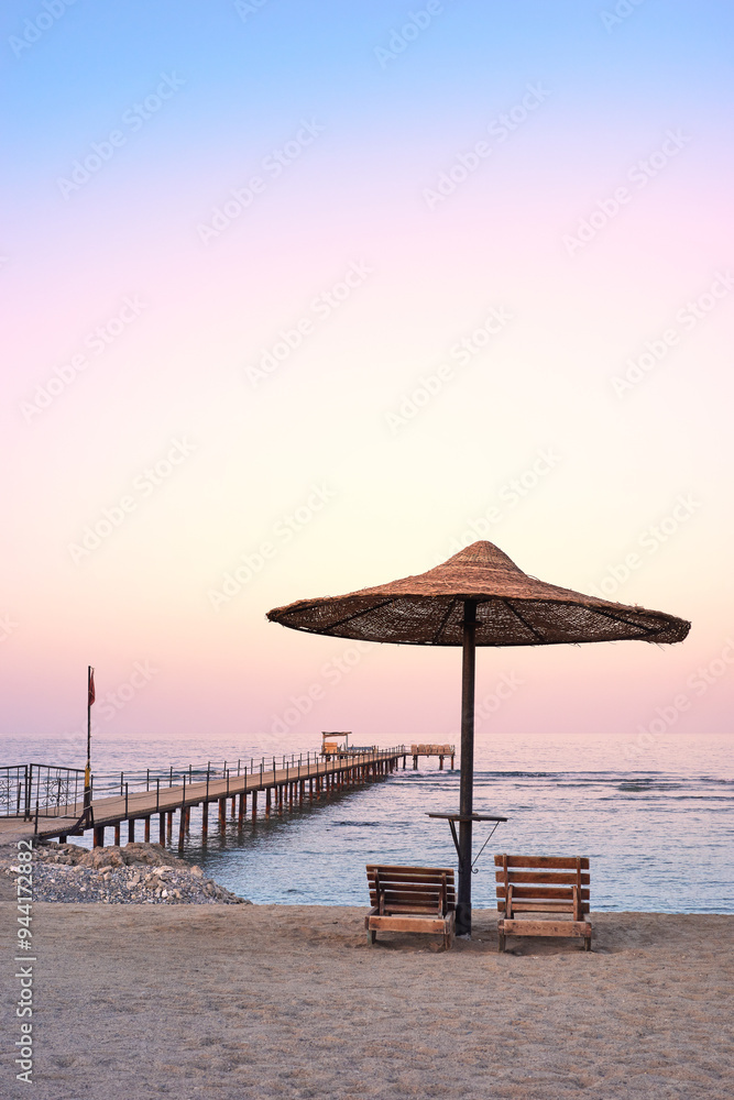 Photo of an empty beach at a purple sunset. Photo of an empty beach at a purple sunset.