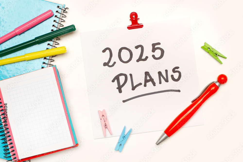 Cartel con planes de tareas , material de oficina y cuadernos sobre fondo blanco. Concepto de objetivos de año nuevo. Vista superior y de cerca. Copy space Cartel con planes de tareas , material de oficina y cuadernos sobre fondo blanco. Concepto de objetivos de año nuevo. Vista superior y de cerca. Copy space