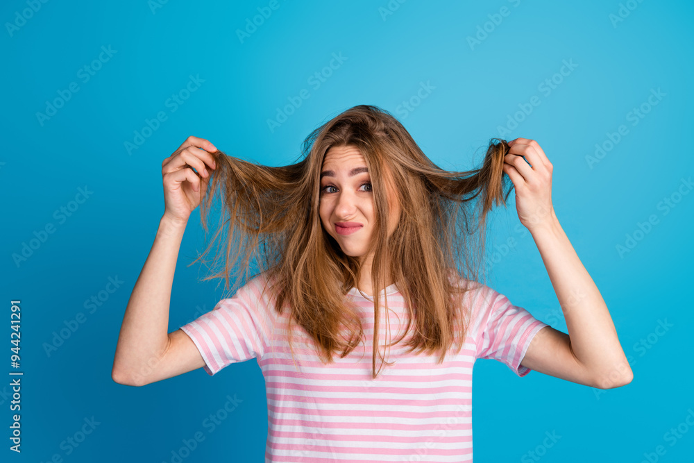 Photo of charming cute woman wear trendy pink clothes hold hair isolated on blue color background Photo of charming cute woman wear trendy pink clothes hold hair isolated on blue color background