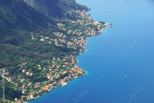 Aerial view of Prcanj, built on the Adriatic coast in the Bay of Kotor: a winding coastline, houses and the central part of the settlement with the church of the Birth of the Blessed Virgin Mary photo