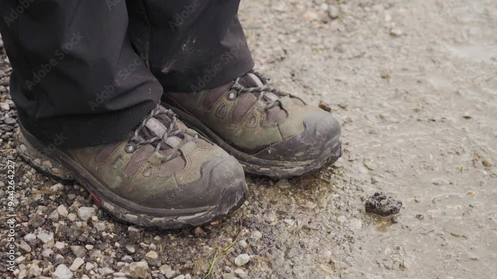 A person's feet are shivering because of the cold temperatures outside, close-up shot, overcast summer day, wet, muddy ground A person's feet are shivering because of the cold temperatures outside, close-up shot, overcast summer day, wet, muddy ground