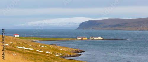 Landscape in autumn with fjord, mountains and a small harbor in northwest Iceland