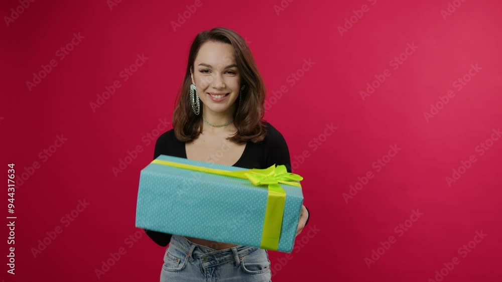 An attractive woman in stylish clothes with a gift for a holiday. A box with a bright ribbon An attractive woman in stylish clothes with a gift for a holiday. A box with a bright ribbon