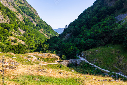 Petit pont de pierre enjambant le Neste d’Oô depuis le Lac d’Oô dans  dans les Pyrénées à côté de Bagnères-de-Luchon photo