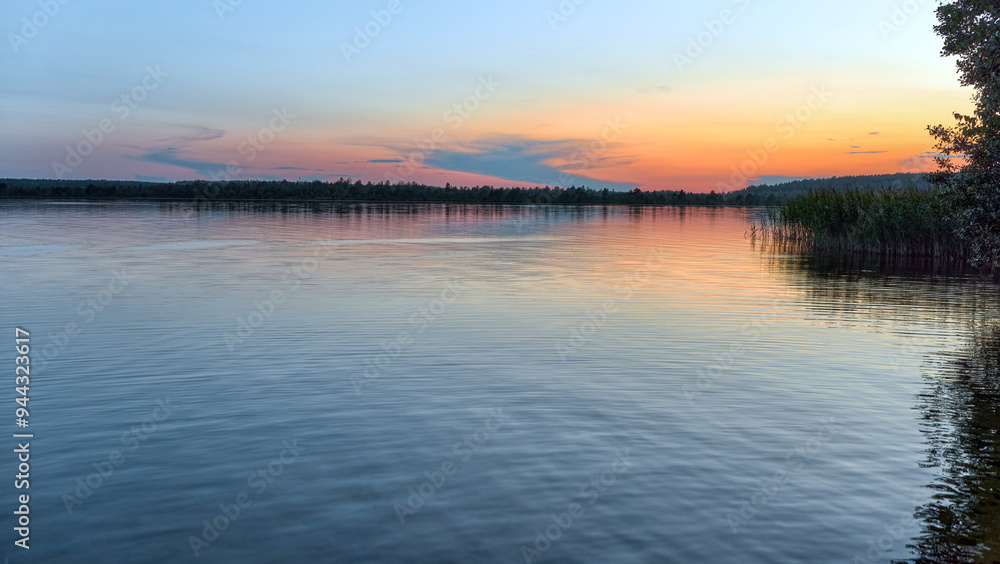 Fototapeta premium Beautiful summer sunset on Rubskoe lake. The water surface of the lake at sunset.