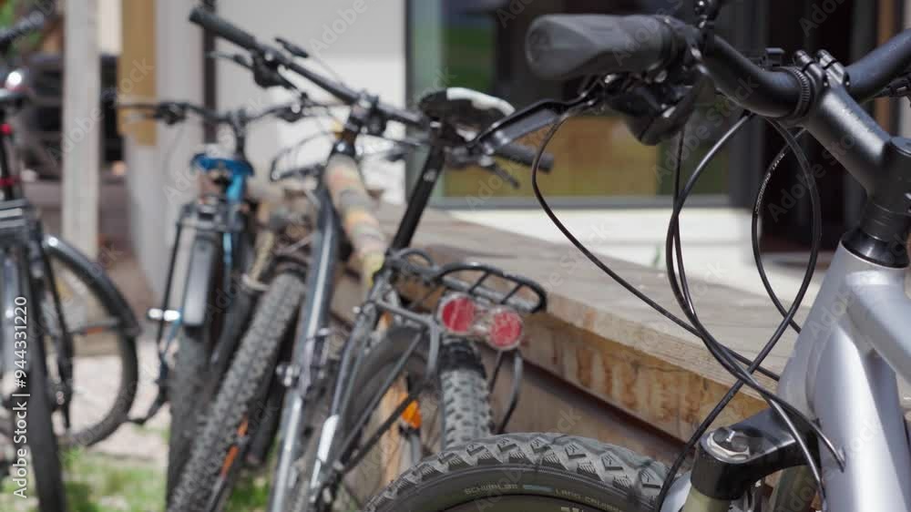 Close up shot of Mountainbikes lean against a fence made Out of wood Close up shot of Mountainbikes lean against a fence made Out of wood