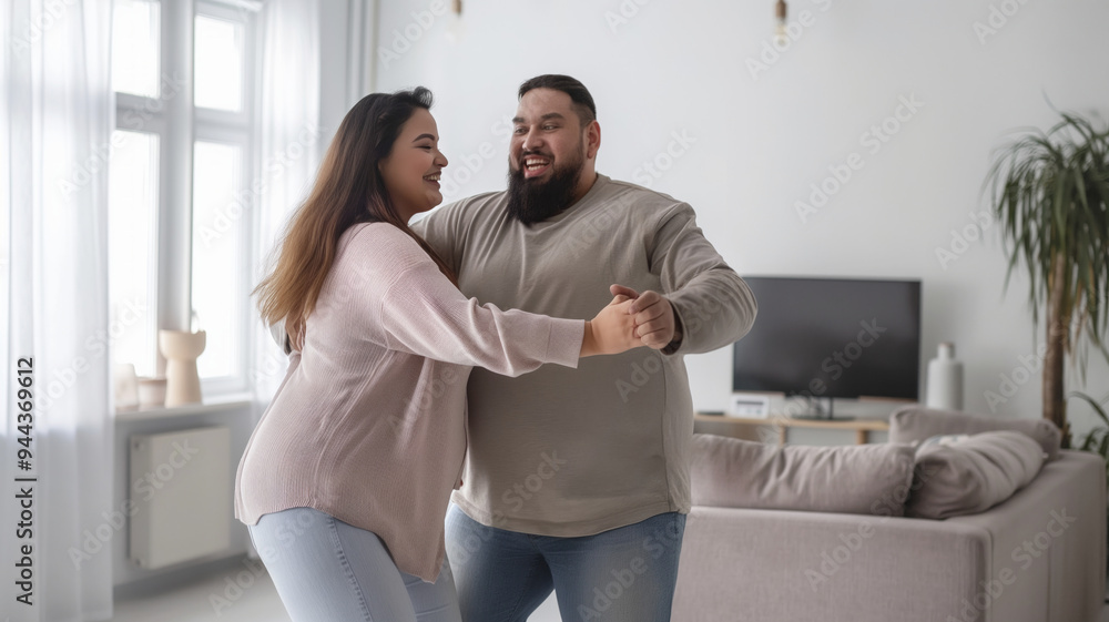 Overweight couple smiling and dancing together in a cozy living room, enjoying a joyful and affectionate moment at home Overweight couple smiling and dancing together in a cozy living room, enjoying a joyful and affectionate moment at home
