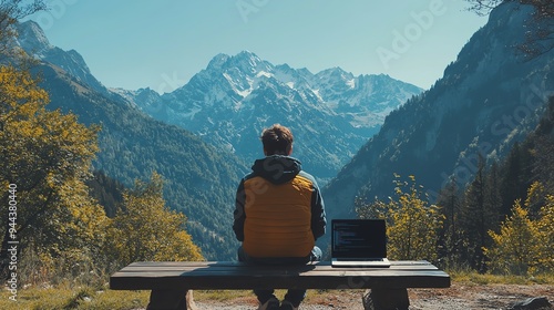 Man working on laptop with mountain view.