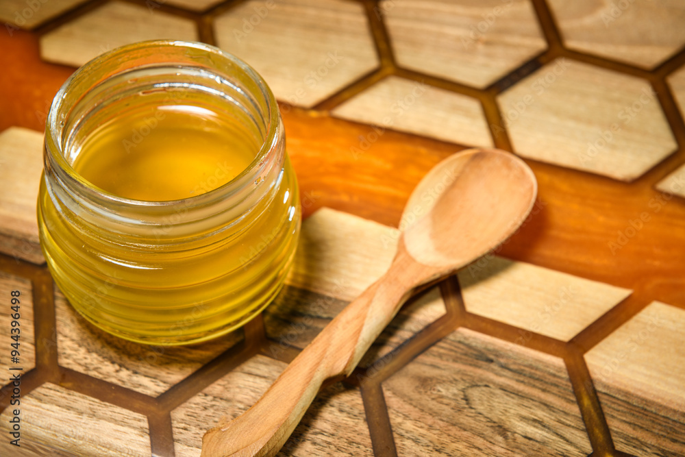Golden honey in glass jar with spoon Golden honey in glass jar with spoon