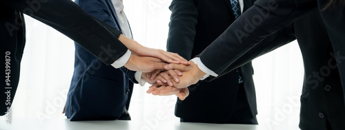 Office worker team stacking hand together symbolize successful group of business partnership and strong collective unity teamwork in community workplace in panoramic banner. Shrewd