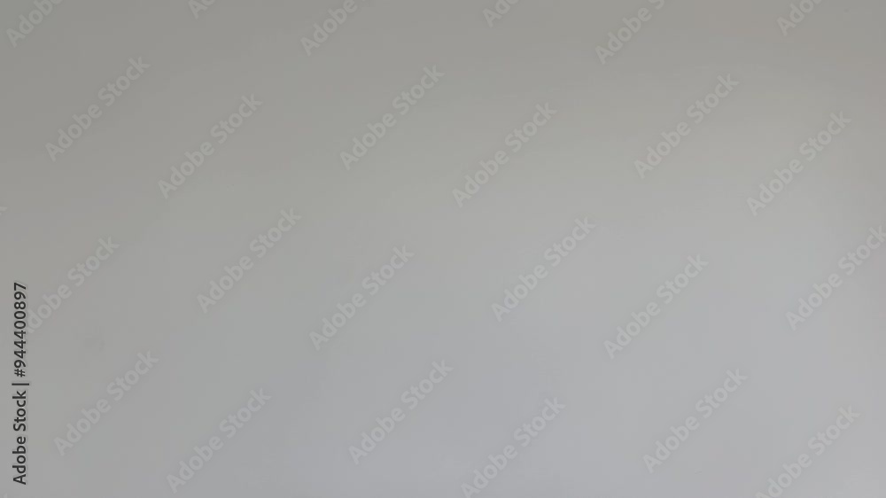 Close-up of a worker using a sanding block on a wall before painting. Close-up of a worker using a sanding block on a wall before painting.