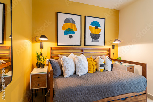 Canvastavla A modern, minimalist bedroom with two single beds featuring wooden frames and gray quilted bedding
