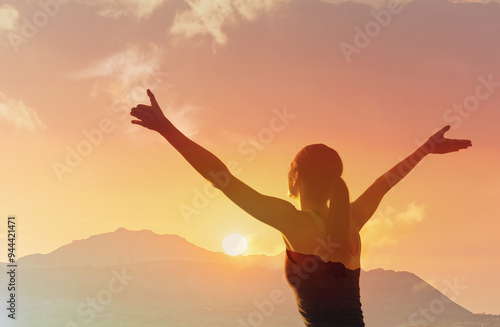 Happy joyful woman standing with her back on sunset in nature .