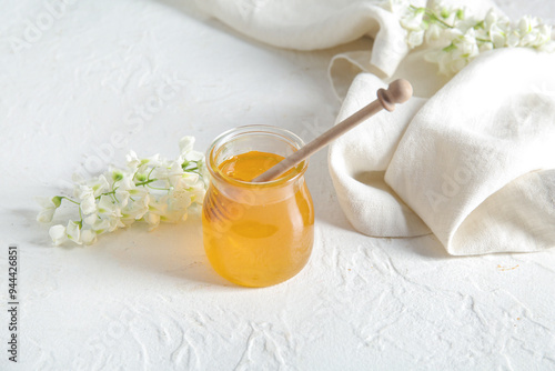 Jar of golden honey with wo...