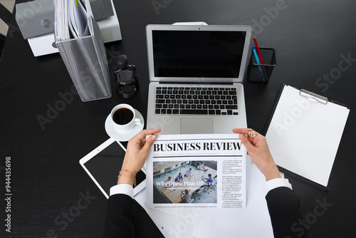 Businesswoman reading newsp...