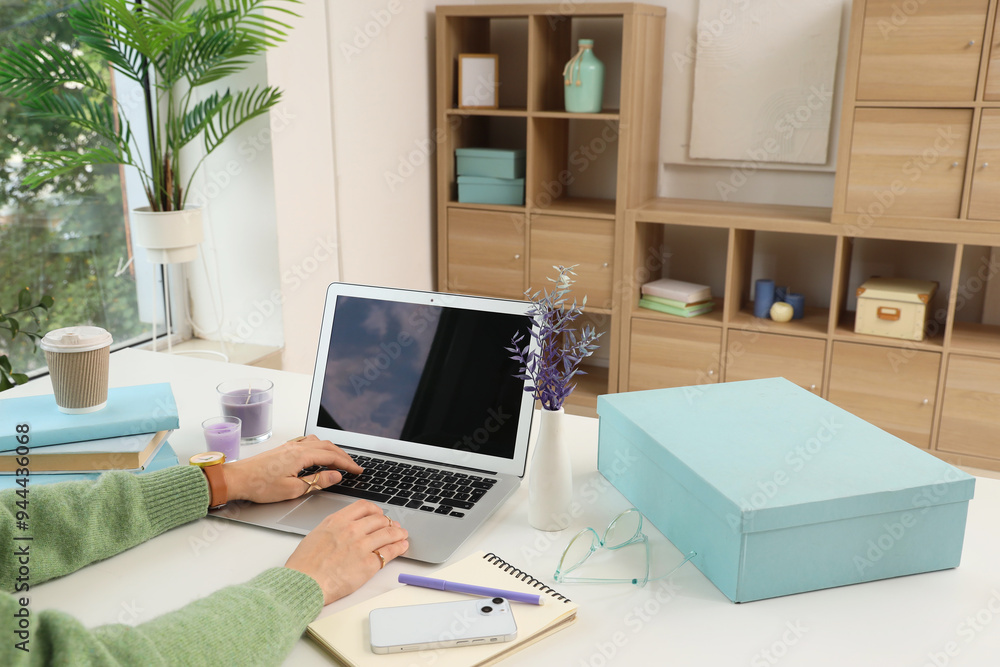 Woman using laptop at table in office, closeup Woman using laptop at table in office, closeup