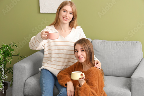 Young women with cups of te...