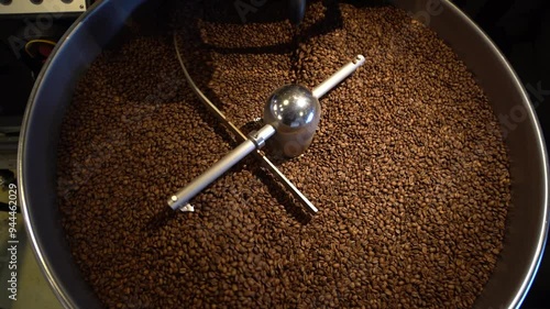 Macro close up: Coffee seeds or beans in a roasting machine, mixing aroma beans. Preparation fresh aroma caffeine on manufacturing warehouse. Production of fresh fried coffee