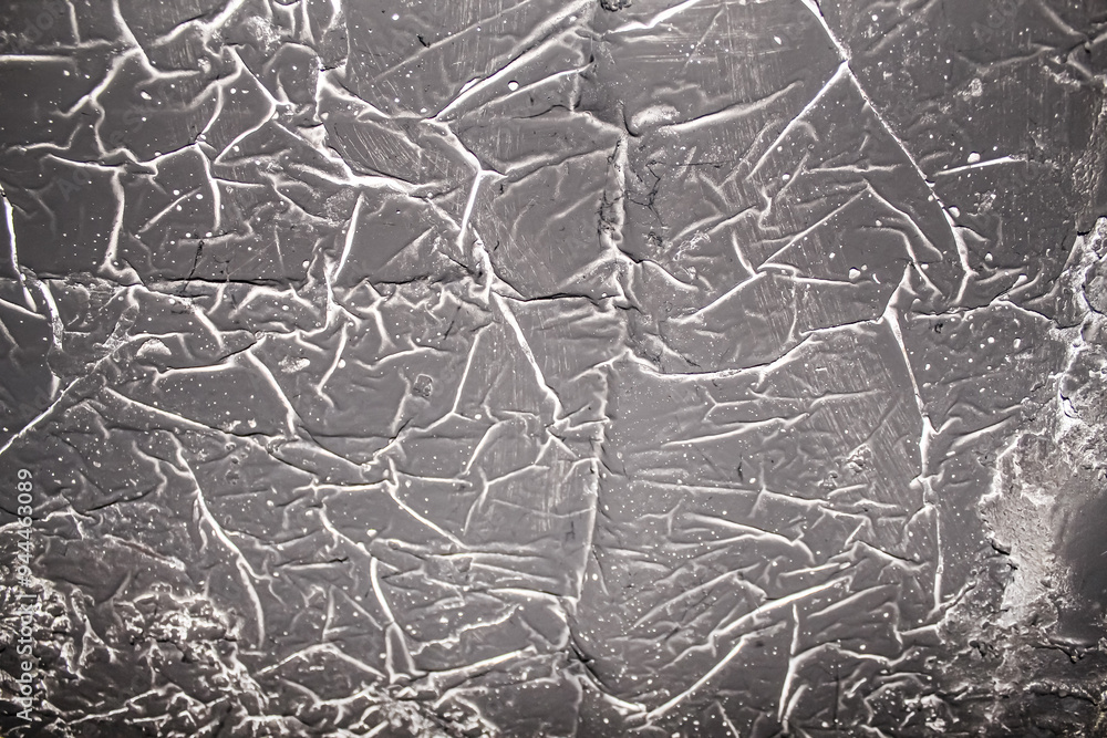 Obraz premium Close-up of textured gray wall with intricate crack patterns revealing an aged, weathered surface during daylight