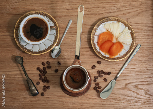 Breakfast with cup of coffee, butter and apricot jam included vintage serving pieces top view photo