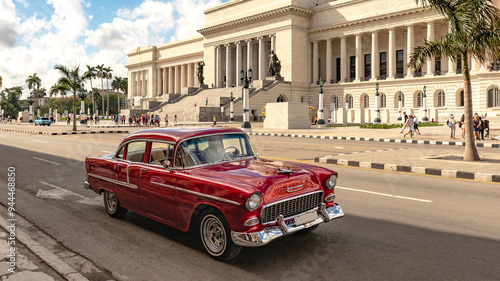 red classic car in front of historical building in the streets of havanna cuba