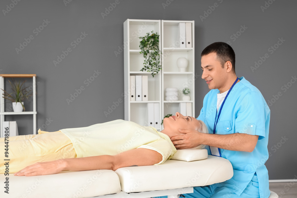 Male physiotherapist working with mature woman on couch in rehabilitation center Male physiotherapist working with mature woman on couch in rehabilitation center