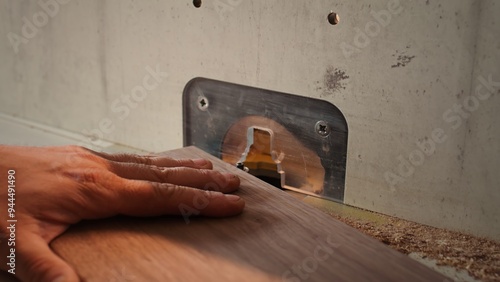 Woodworker operating spindle moulder to create high quality bespoke joinery for customer commissioned project. Machinist at work performing tasks on wood shaper, shaping materials, camera B close up photo