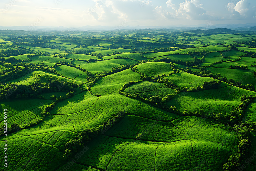 divided fields, surrounded by hills and mountains under a cloudy sky divided fields, surrounded by hills and mountains under a cloudy sky