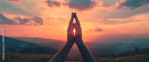 Silhouette of hands clasped in prayer at sunset.