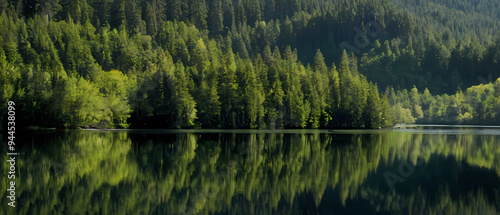 Mountains surround a lake reflecting trees.